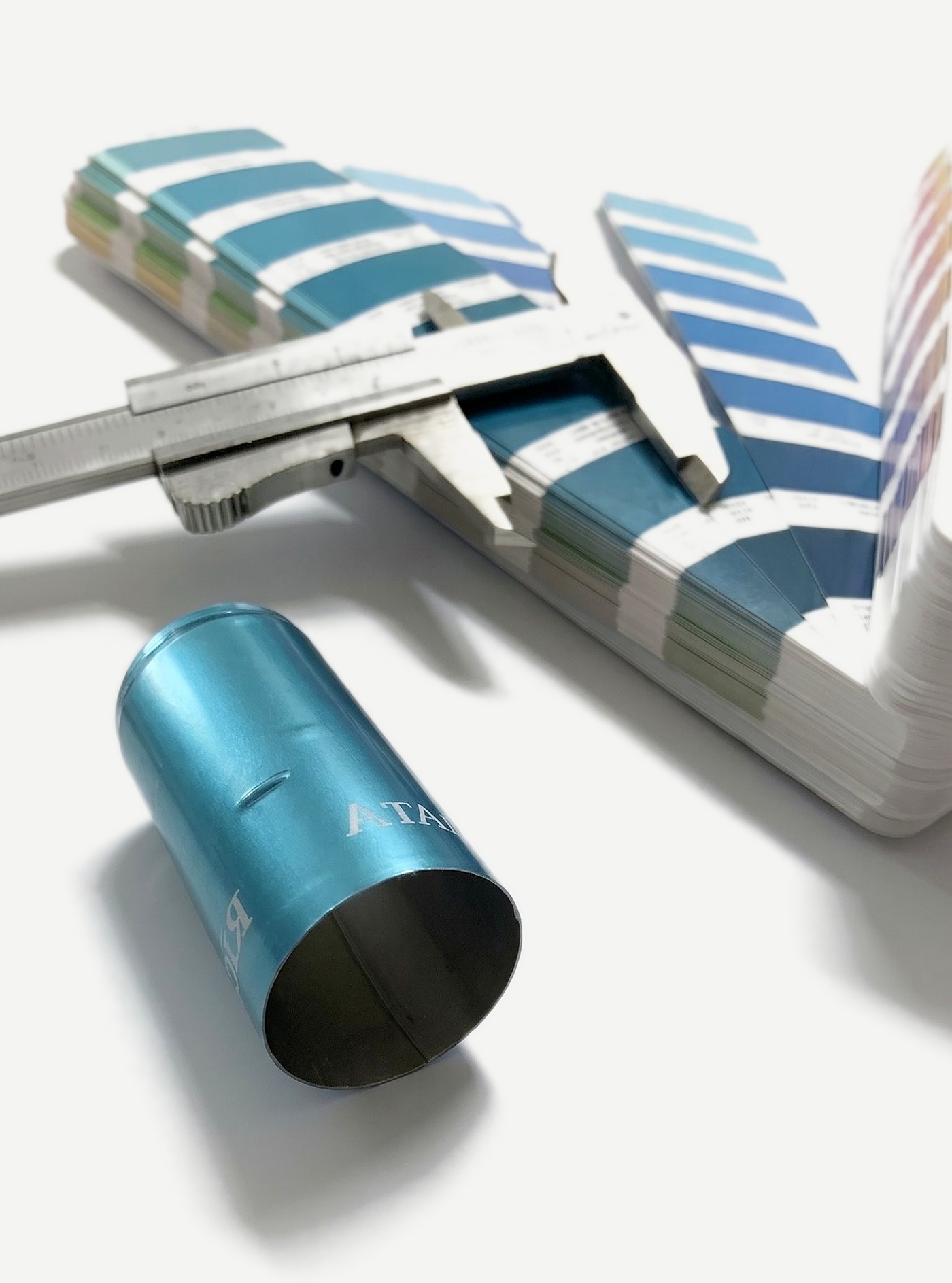 Capsula azzurra personalizzata accanto a un calibro e a una mazzetta colori